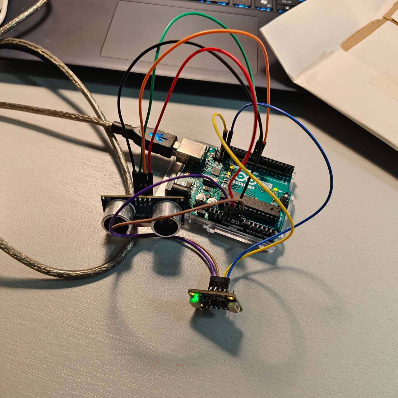 Arduino Uno connected to an ultrasonic sensor and a range finder sensor for testing entry/exit detection logic.